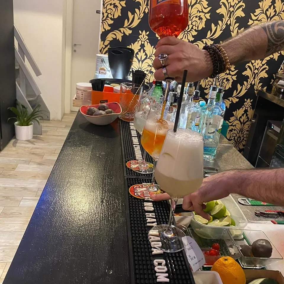 Il barman prepara una fila di cocktail sul bancone
