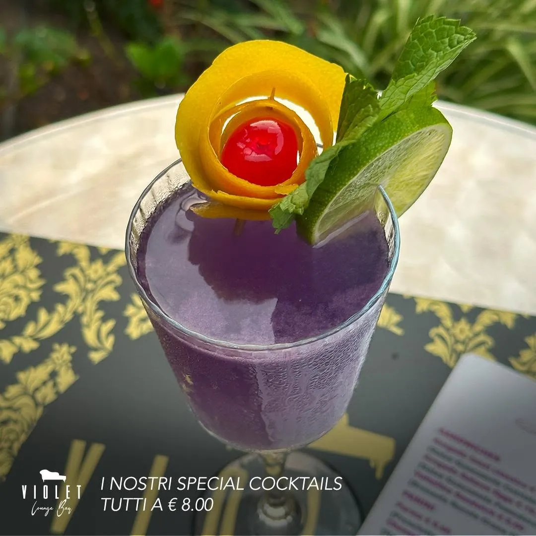 Special cocktail viola con scorza d'arancia, lime e menta