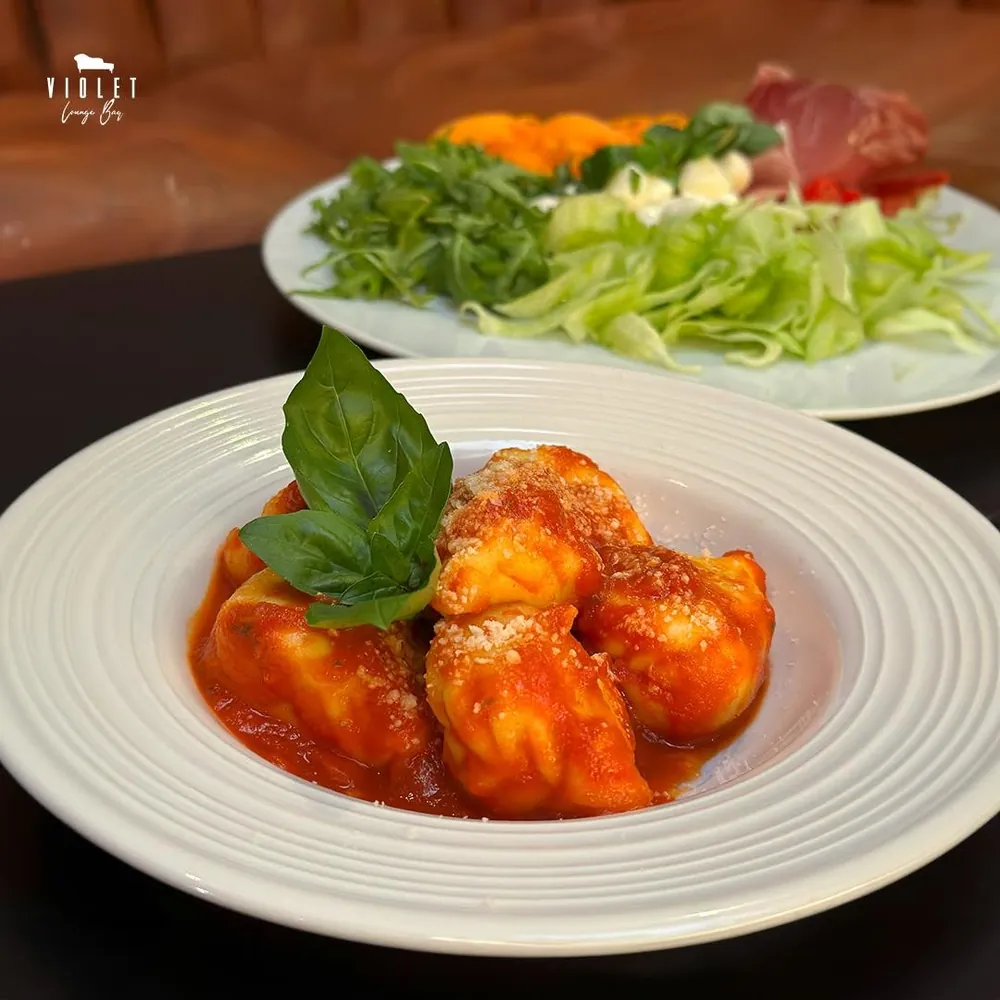 Tortelli al pomodoro con basilico e tagliere di verdure e salumi